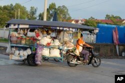 អាជីវករម្នាក់ដឹកទំនិញលក់តាមតូបចល័ត នៅជាយរាជធានីភ្នំពេញ កាលពីថ្ងៃទី ២០ ខែកញ្ញា ឆ្នាំ ២០២៣។