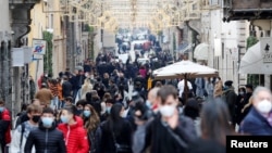 Warga mengenakan masker saat berbelanja menjelang Natal di tengah pandemi Covid-19 di Roma, Italia, 19 Desember 2020. (Foto: dok).