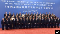 Chinese President Xi Jinping, ninth from right, poses for a group photo with Swiss Economy Minister Johann Schneider-Ammann, ninth from left, and delegates attending the signing ceremony for the Articles of Agreement of the Asian Infrastructure Investment