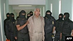 (FILES) This handout picture released by the Mexican Federal Preventive Police (PFP) shows members of the Federal Preventive Police guarding drug trafficker Rafael Caro Quintero (C) after an operation at the Puente Grande prison in Guadalajara, Jalisco, 4