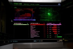 FILE - Financial market information is displayed on a big screen inside the London Stock Exchange, Tuesday, Aug. 25, 2015.