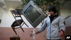 In this Wednesday, Nov. 20, 2019, photo, Mohammed al-Shenbari demonstrates to balance objects using what he calls a mix of mind and body, in the yard of his home in Beit Hanoun, northern Gaza Strip. (AP Photo/Hatem Moussa)