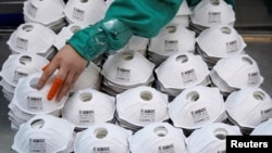 Masker-masker yang baru diproduksi di sebuah pabrik di Shanghai, China, 31 Januari 2020.