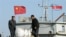 FILE - North Korean men stand on a boat used for trade between China and North Korea on the waterfront at the North Korean town of Sinuiju, opposite the Chinese border city of Dandong, Oct. 11, 2006.