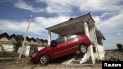 A car damaged by floods is seen after heavy rainfalls hit Zhou Kou Dian Village, Fangshan district, near Beijing, China, July 22, 2012. 
