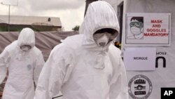 FILE - Health workers are seen wearing Ebola protective gear at an Ebola treatment center at Tubmanburg on the outskirts of Monrovia, Liberia, Nov. 28, 2014.