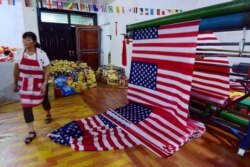 FILE - A Chinese employee walks past new U.S. flags at a factory in Fuyang in China's eastern Anhui province, July 13, 2018. China says its factory production is the weakest in 17 years.