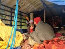 Protesters huddle inside tractors during Delhi's cold winter. (A. Pasricha/VOA)