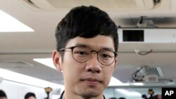 FILE - Pro-democracy activist Nathan Law, along with Agnes Chow and Joshua Wong, attends a press conference in Hong Kong, Jan. 27, 2018.