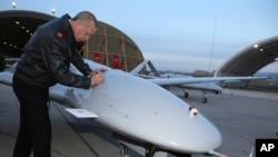 Presiden Turki Recep Tayyip Erdogan menandatangani drone di pangkalan udara militer di Batman, Turki, Sabtu, 3 Februari 2018. Militer Turki mengatakan dua tentaranya tewas di Suriah. (Foto: AP)