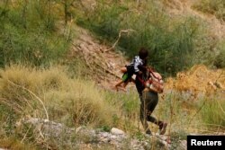 미국 난민 신청 희망자가 지난 8일 멕시코에서 아이와 함께 텍사스주 엘파소 국경을 넘고 있다. (자료사진)