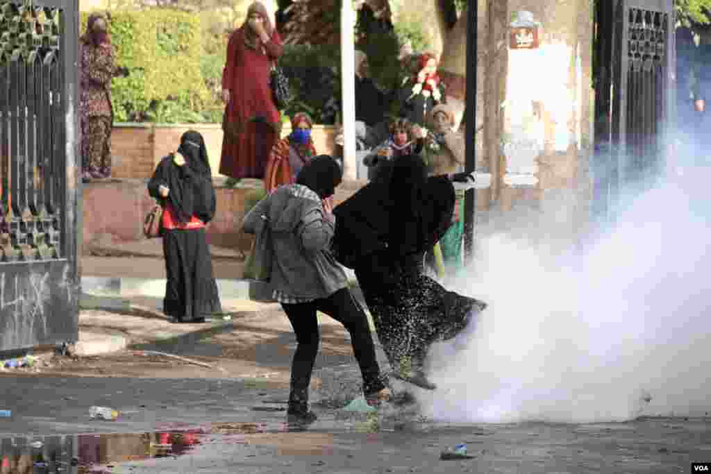 Women react to tear gas during a protest at Al-Azhar University in Cairo, Dec. 11, 2013. (Hamada Elrasam for VOA)