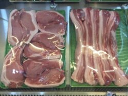 FILE - A butcher in Ho Chi Minh City sells pork, whose price increases are feeding fears of inflation in Vietnam.