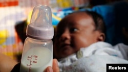 Seorang ibu di Jakarta, tengah memegang botol susu anaknya, 7 Agustus 2012. (Foto: ilustrasi). 