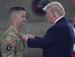 U.S. President Donald Trump awards the Distinguished Flying Cross to California National Guard Sergeant Cameron Powell during a ceremony to honor Powell and six other helicopter crew members at McClellan Park, California, Sept. 14, 2020.