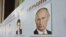 A board with the profiles of various presidential candidates, amongst them Russia's current Prime Minister Vladimir Putin, is on display during the preparations for the upcoming presidential elections at a polling station in the southern Russian city of S