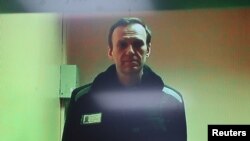 Pemimpin Oposisi Rusia Alexei Navalny terlihat di layar melalui tautan video dari koloni hukuman di wilayah Vladimir selama sidang di Pengadilan Distrik Basmanny di Moskow, Rusia, 26 April 2023. (Foto: Reuters/Yulia Morozova)