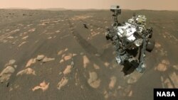 This April 6, 2021 image made available by NASA shows the Perseverance Mars rover, foreground, and the Ingenuity helicopter about 3.9 meters behind. This composite image was made by the WASTON camera on the rover's robotic arm. (NASA/JPL-Caltech/MSSS via AP)