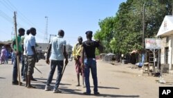 1일 나이지리아 보르노주 마이두구리시에서 두 건의 폭탄테러가 발생한 후 자경단원들이 도로를 차단하고 있다. 