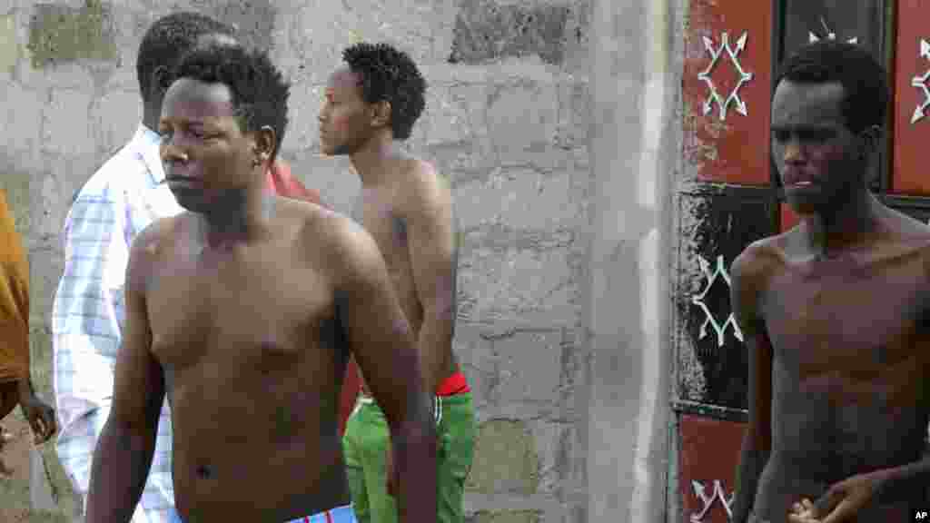 Torses nues, des étudiants sortent d&#39;une maison où ils ont cherché refuge après avoir échappé à une attaque des hommes armés à Garissa, au Kenya, jeudi 2 Avril, 2015