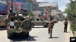 Pasukan keamanan Afghanistan berjaga di lokasi serangan bersenjata di Kabul, Afghanistan, 12 Mei 2020.