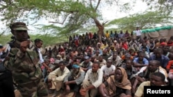 FILE - Members of the militant group al Shabab listen to a Somalia government soldier after their surrender to the authorities in Mogadishu, Sept. 24, 2012.