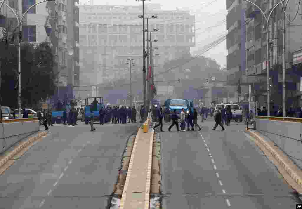 Iraqi security forces and people gather at the site of a road side bomb attack in central Baghdad, Jan. 5, 2014. 