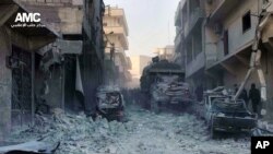 Warga Suriah memeriksa bangunan-bangunan yang hancur pasca serangan udara pasukan pemerintah Suriah di Aleppo (Foto: dok). Pasukan Suriah dilaporakan kembali melancarkan serangan udara, kali ini di kota Bzaa, dan menewaskan sedikitnya 10 orang, Senin (6/1).