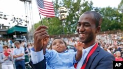 Alpha Saliou Diallo, un réfugié guinéen avec sa fille Aisha, après être devenu citoyen américain lors d'une cérémonie spéciale, Journée mondiale des réfugiés, Central Park, New York, le 20 juin 2016. (AP Photo/Kathy Willens)
