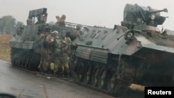 Soldiers stand beside military vehicles just outside Harare, Zimbabwe, Nov. 14,2017.