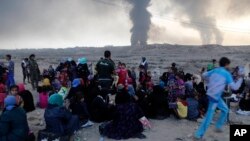 Smoke rises as people flee their homes during clashes between Iraqi security forces and members of the Islamic State group fleeing Mosul, Iraq, Oct. 18, 2016. 