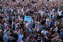FILE - Members of Pakistan's Pashtun community chant slogans and take photos of their leader Manzoor Pashteen (unseen) during a rally by the Pashtun Tahafuz Movement (PTM) against alleged human rights violations, in Lahore, Pakistan, April 22, 2018.