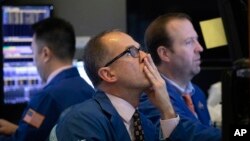 Traders monitor stock prices at the New York Stock Exchange, Thursday, Jan. 2, 2020. Global shares rose Thursday on optimism about a U.S.-China trade deal and the Chinese government's efforts to boost its economy. (AP Photo/Mark Lennihan)