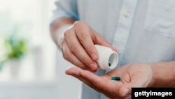 Capsule in palm of hand. 