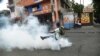 A demonstrator kicks a tear gas canister during clashes with Haitian police in Port-au-Prince, Feb. 15, 2019, on the ninth day of protests against Haitian President Jovenel Moise.
