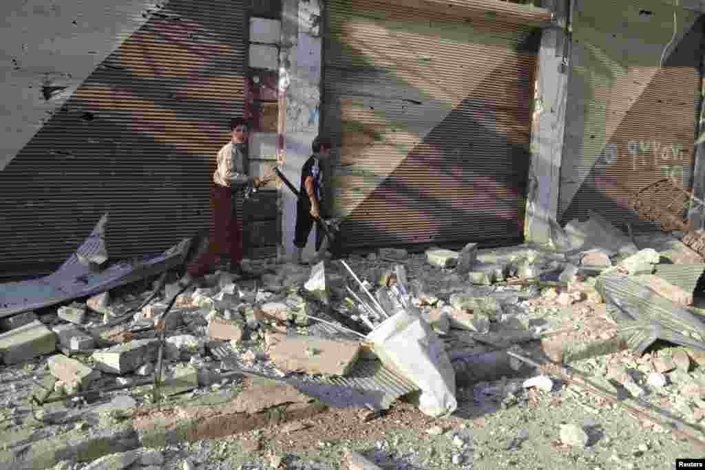 Boys walk on debris in Marat al-Numan, near the northern province of Idlib July 27, 2012.