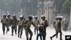 Egyptian army soldiers arrest a woman protester during clashes with military police near Cairo's downtown Tahrir Square, Egypt Friday, Dec. 16, 2011.