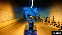 A protester holds a picture of an injured demonstrator, during a demonstration demanding Hong Kong's leaders to step down and withdraw the extradition bill, in Hong Kong, China, June 17, 2019.