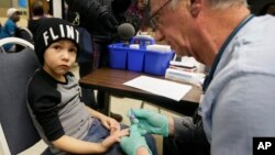 FILE - A nurse draws a blood sample from a student at Eisenhower Elementary School in Flint, Michigan, Jan. 26, 2016. Elevated levels of lead from drinking water have been detected in some children.