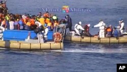 This image taken from video provided by the Italian Navy (Marina Militare) Saturday, Aug. 15, 2015, shows an Italian Navy RIB approaching a fishing boat crowded with migrants off the coast of Libya.