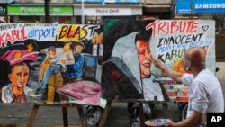 An artist from Gurukul art school works on a poster in Mumbai, India, Aug. 27, 2021, paying tribute to victims of deadly attacks at the airport in Kabul, Afghanistan.