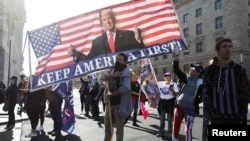 A supporter of U.S. President Donald Trump holds a banner while reciting the Pledge of Allegiance during a "Stop the Steal" protest after the 2020 U.S. presidential election was called for Democratic candidate Joe Biden, in Washington, U.S. November 14, 2020. REUTERS/Jim Urquhart