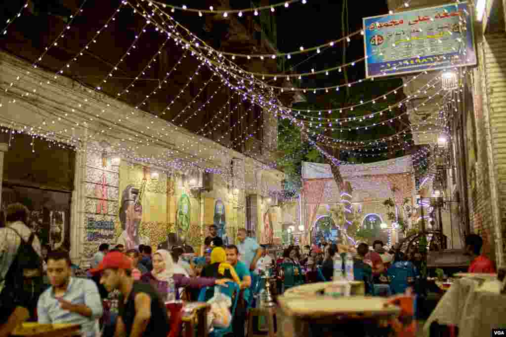 The introduction in recent years of lower-consumption LED bulbs mean many Cairo residents, like patrons and this street caf&#233;, can continue to enjoy bright lights on a summer’s eve. (H. Elrasam/VOA)