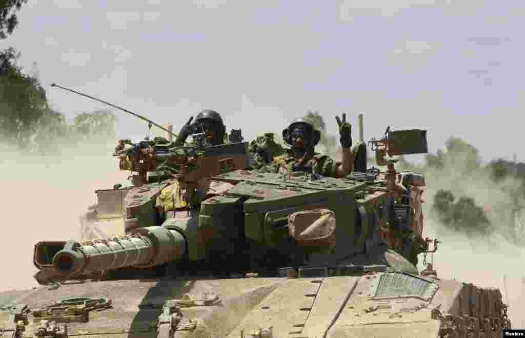 Israeli soldiers atop a tank outside the Gaza Strip, July 18, 2014.