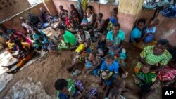 FILE - In this Dec. 11, 2019 file photo, residents of the Malawi village of Tomali wait to have their young children become test subjects for the world's first vaccine against malaria in a pilot program.