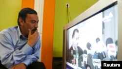 Seorang warga menonton siaran TV di Baghdad, Irak (foto: dok). Irak melarang siaran al-Jazeera dan sembilan televisi satelit lainnya.
