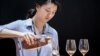 Picture taken on May 27, 2014 shows a woman pouring a glass of cognac at Vinexpo Asia Pacific in Hong Kong. 