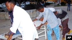 Petugas medis menolong korban luka-luka akibat serangan bom bunuh diri di Mogadishu, Somalia, hari Rabu (24/7). 