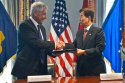 지난 2014년10월 미 국방부에서 열린 안보협의회에서 척 헤이글 미국 국방장관(왼쪽)과 한민구 한국 국방장관이 전작권 전환 연기 각서에 서명한 후 악수하고 있다. (자료사진)