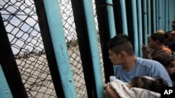 People approach an injured man with a gunshot wound amid protests against the military coup in Yangon, Myanmar, February 28, 2021, in this still image from video obtained via social media. (Credit: Myanmar Now)
